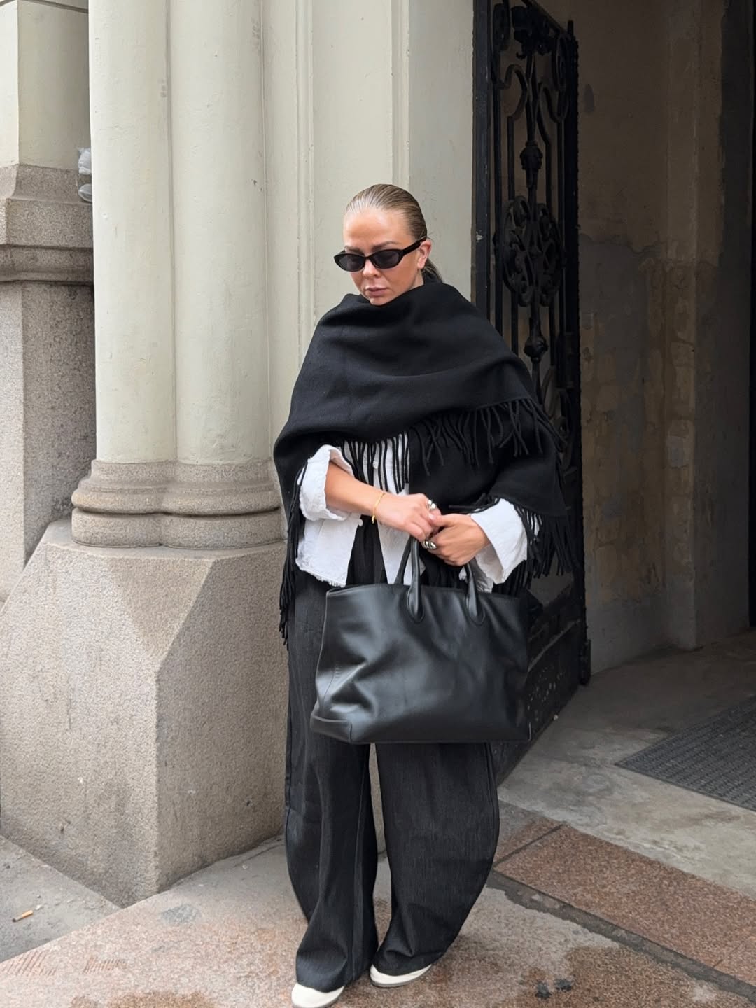 Influencer Dina Hansen in gray wide-leg pants and white sneakers.